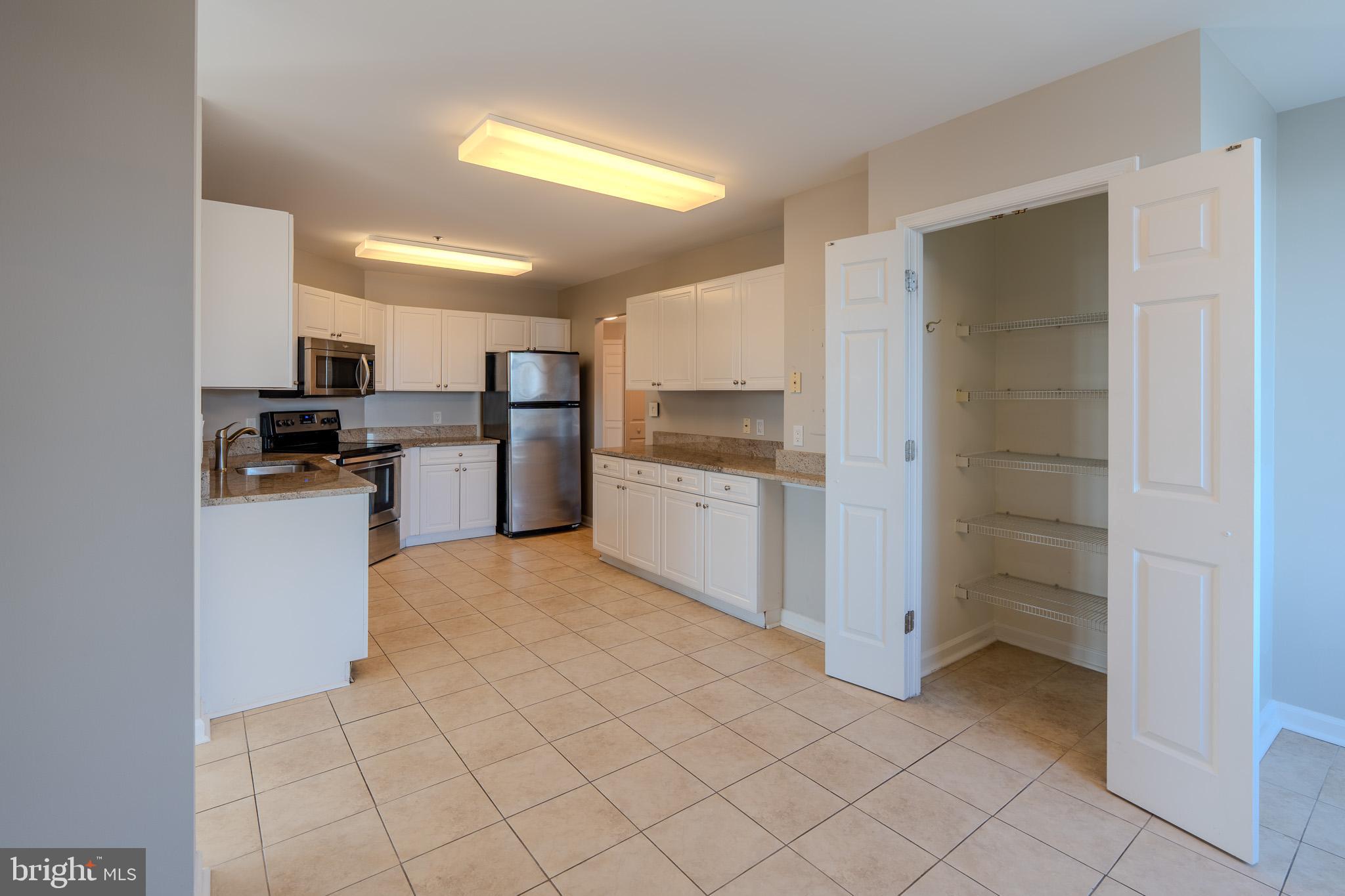 100 Harborview Drive, Unit 302 Baltimore, MD 21230 - Photo 35 of 48 a kitchen with a refrigerator and a stove top oven
