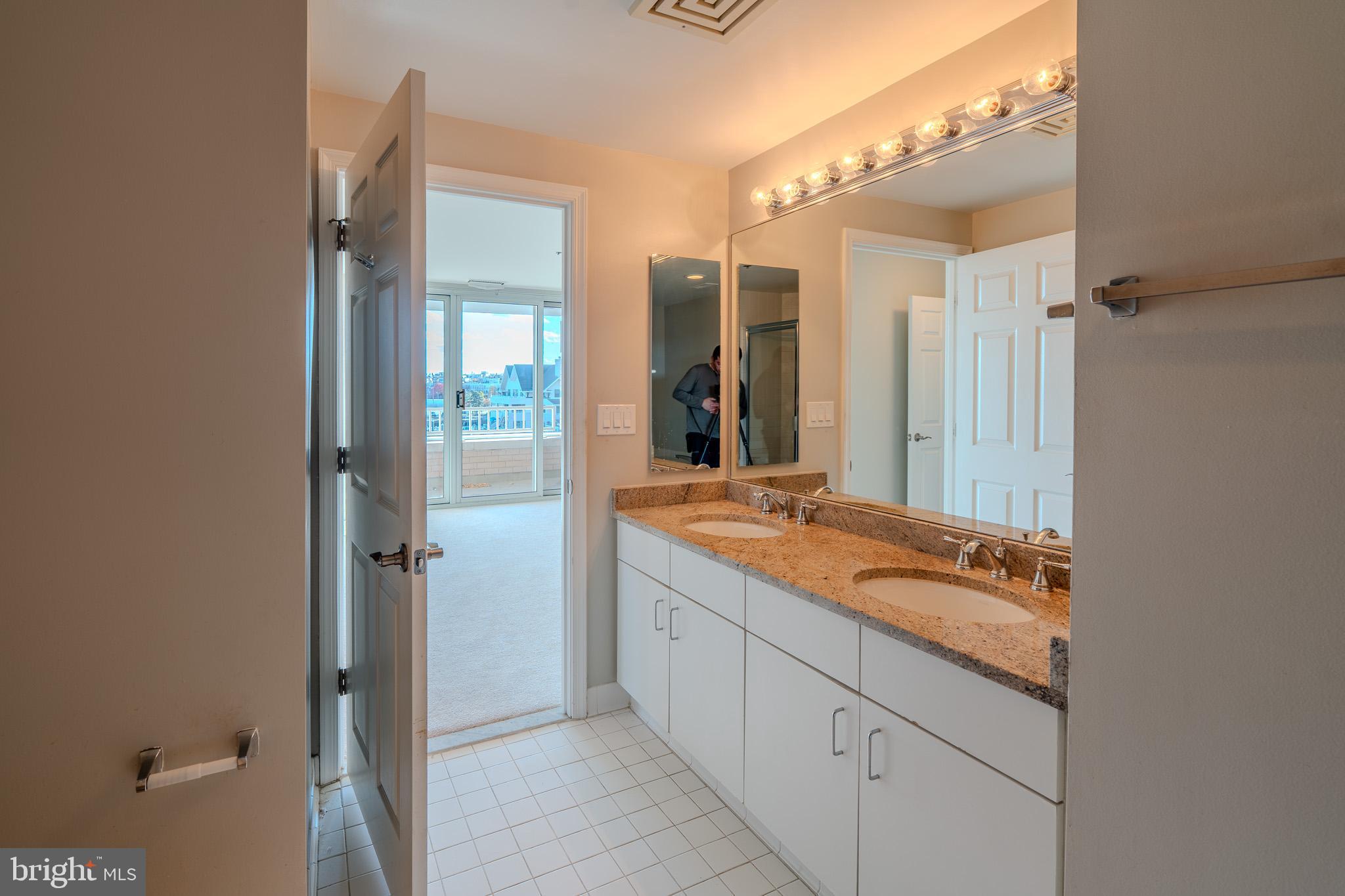 100 Harborview Drive, Unit 302 Baltimore, MD 21230 - Photo 45 of 48 a bathroom with a granite countertop sink and a mirror