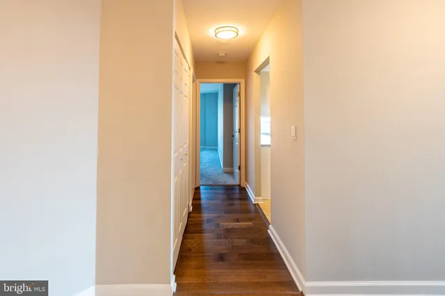a view of a hallway with wooden floor