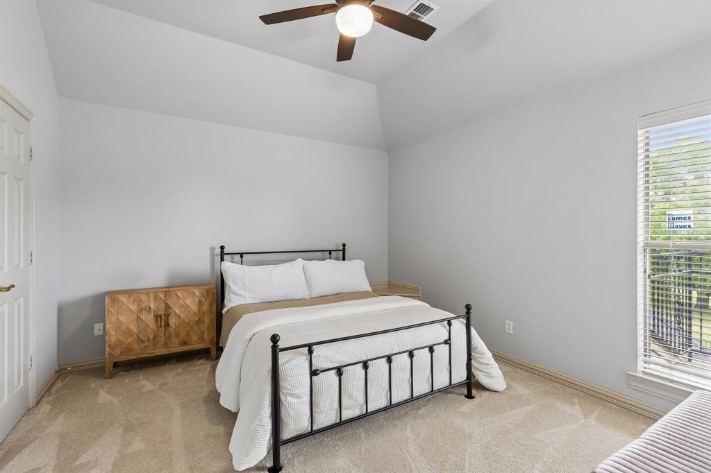 8517 Navigation Drive Rowlett, TX 75088 - Photo 32 of 39 a bedroom with a bed and a chandelier fan