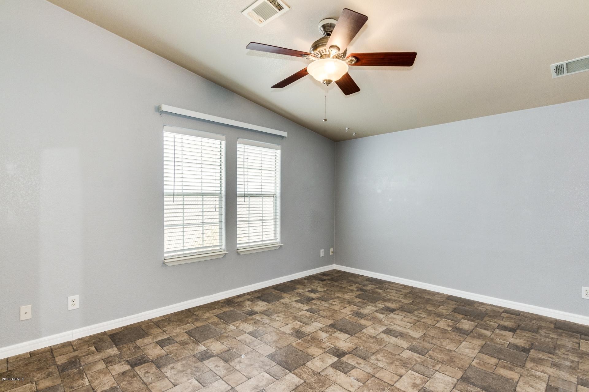 3301 South Goldfield Road, Unit 2041 Apache Junction, AZ 85119 - Photo 11 of 26 an empty room with a window and a fan