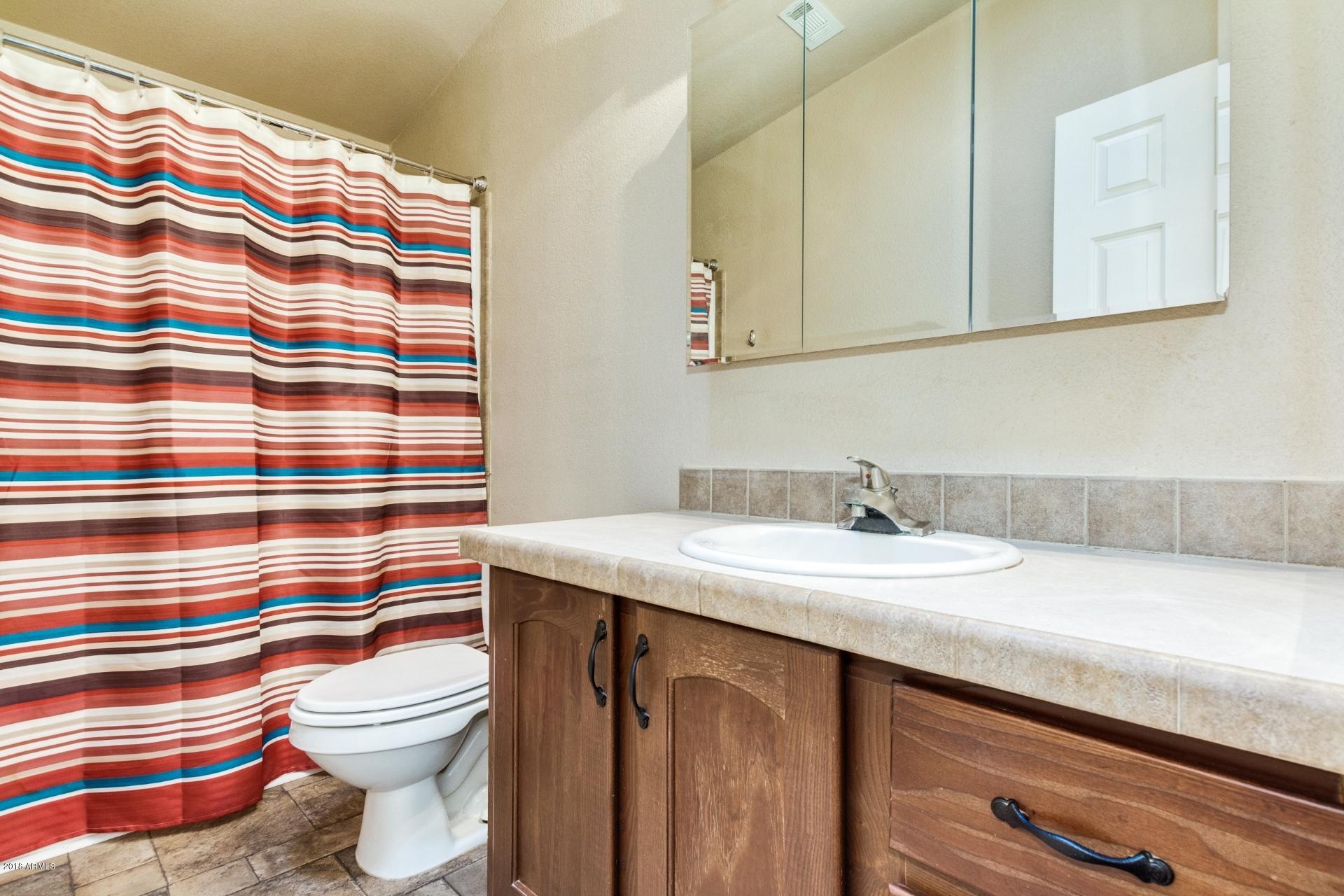 3301 South Goldfield Road, Unit 2041 Apache Junction, AZ 85119 - Photo 12 of 26 a bathroom with a sink a toilet and a mirror