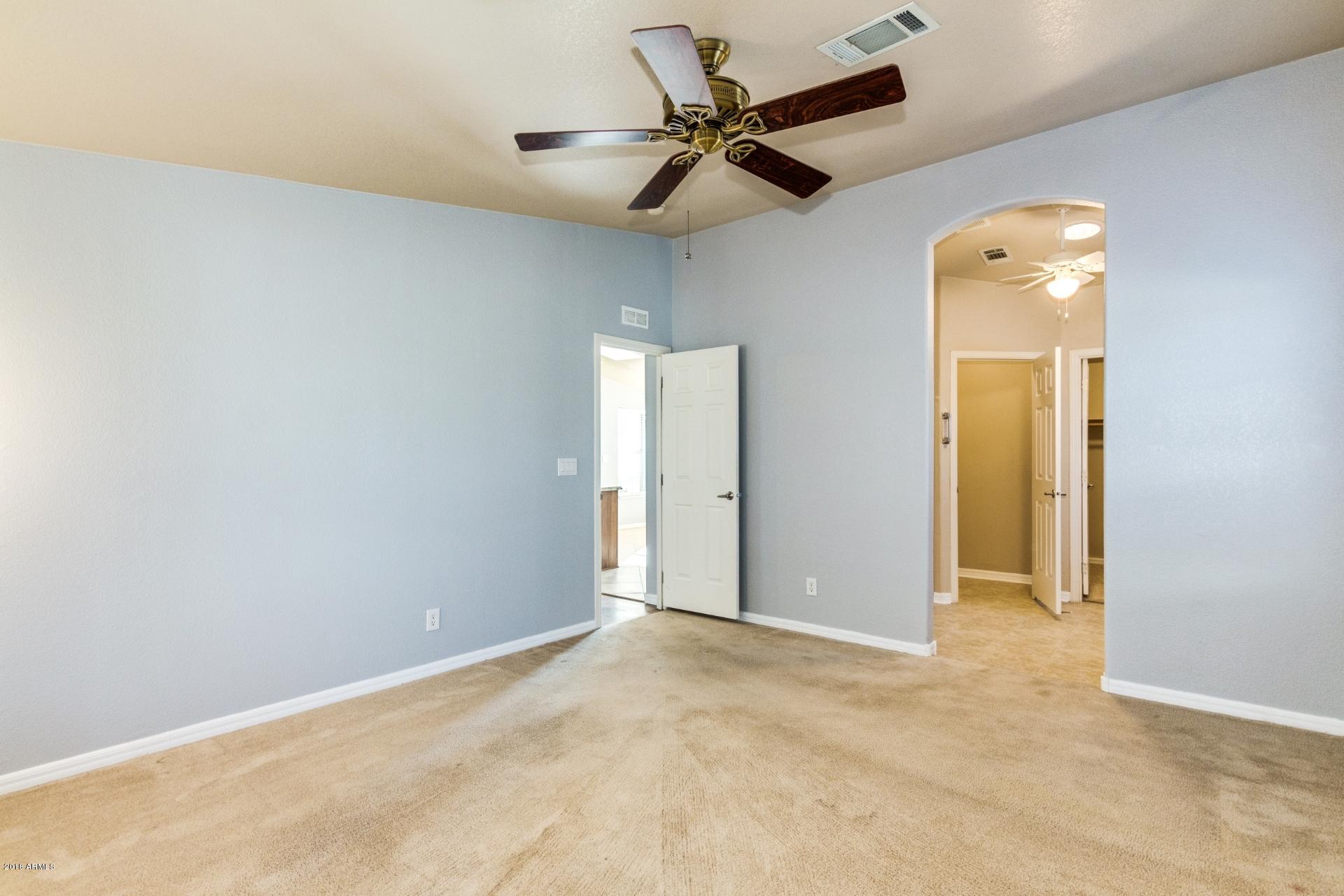 3301 South Goldfield Road, Unit 2041 Apache Junction, AZ 85119 - Photo 13 of 26 an empty room with a ceiling fan and window