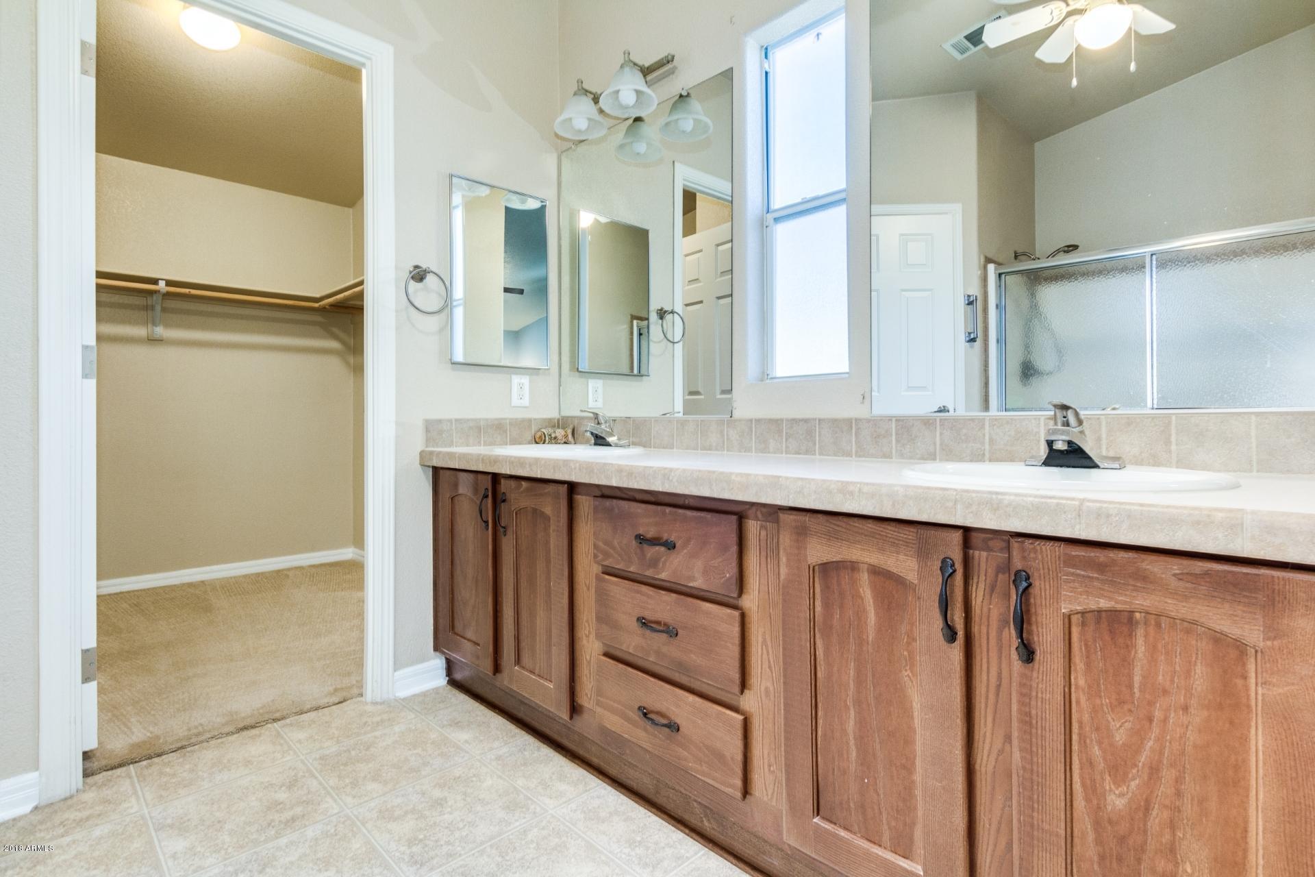 3301 South Goldfield Road, Unit 2041 Apache Junction, AZ 85119 - Photo 15 of 26 a bathroom with a double vanity sink a mirror and a shower