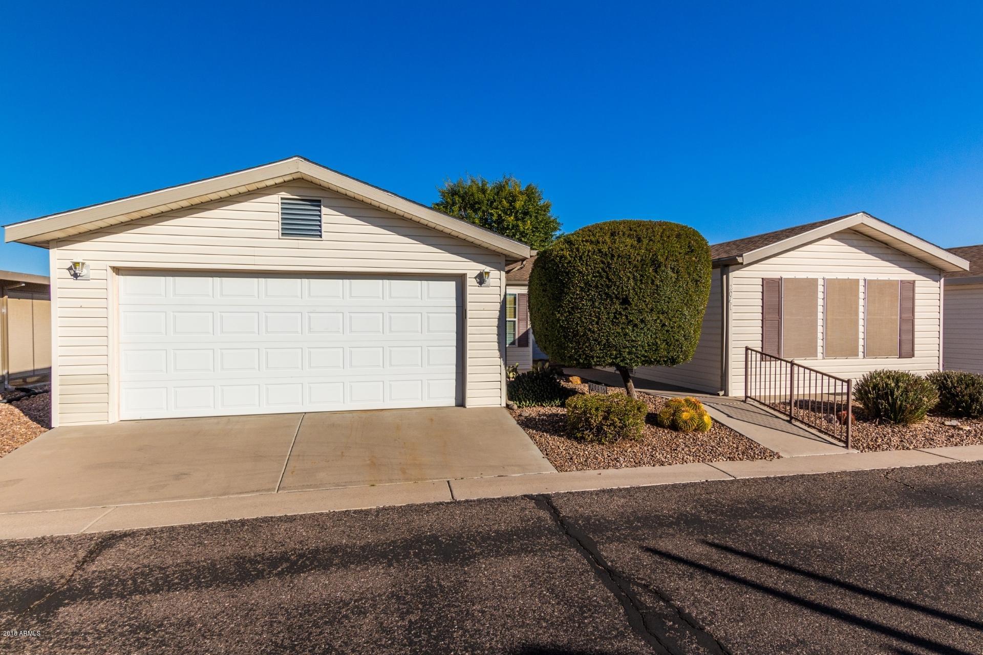 3301 South Goldfield Road, Unit 2041 Apache Junction, AZ 85119 - Photo 2 of 26 a front view of a house with garden
