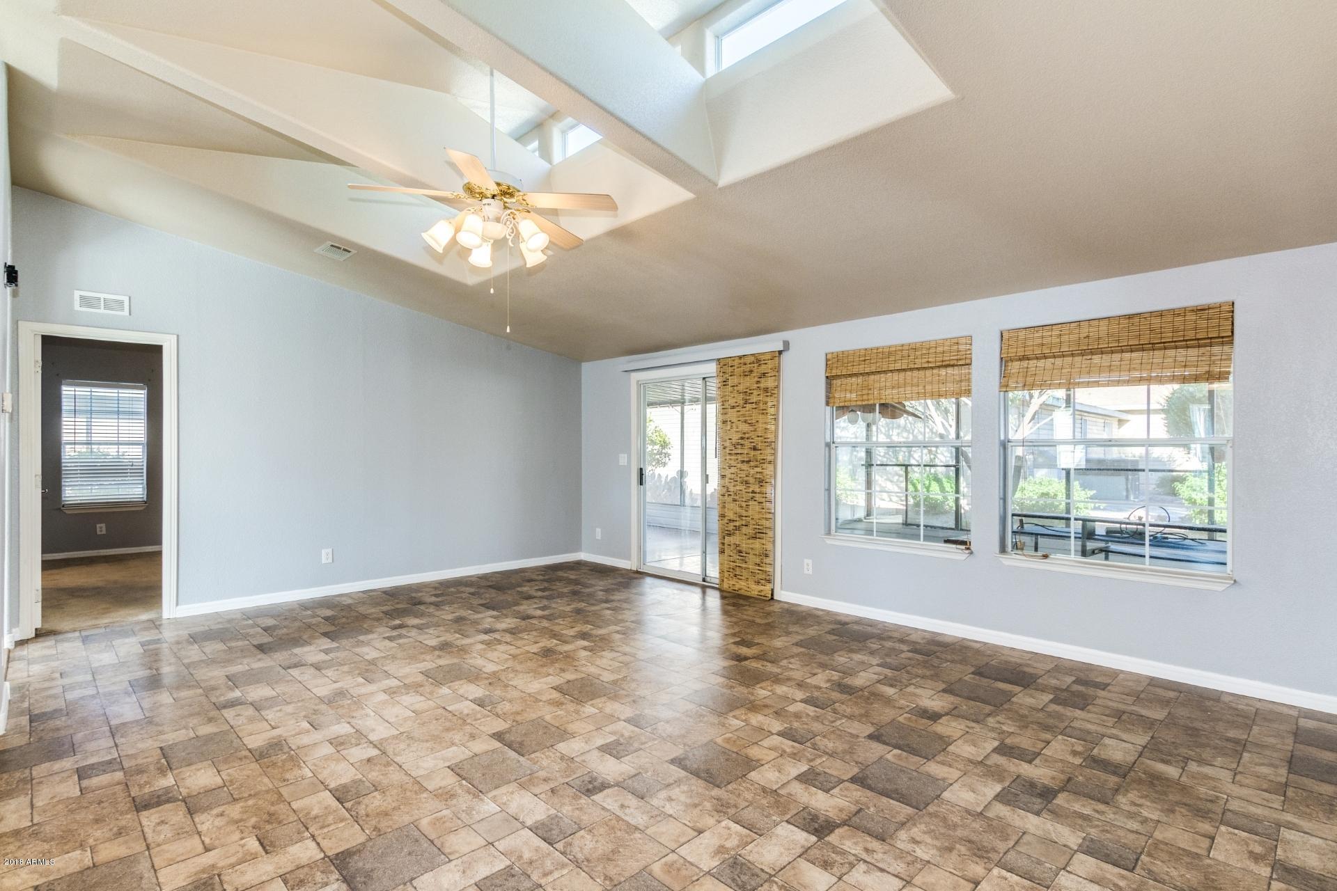 3301 South Goldfield Road, Unit 2041 Apache Junction, AZ 85119 - Photo 4 of 26 a view of an empty room with window and chandelier fan