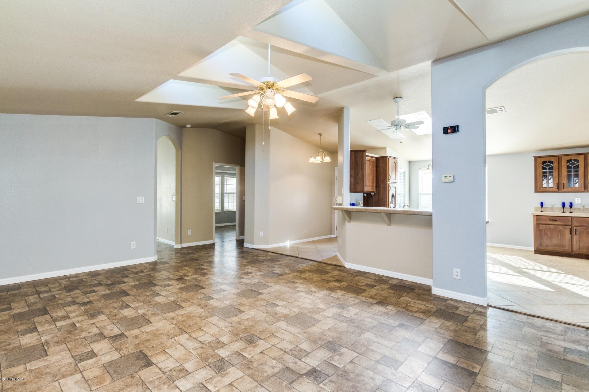 3301 South Goldfield Road, Unit 2041 Apache Junction, AZ 85119 - Photo 5 of 26 a view of a big room with wooden floor and a kitchen