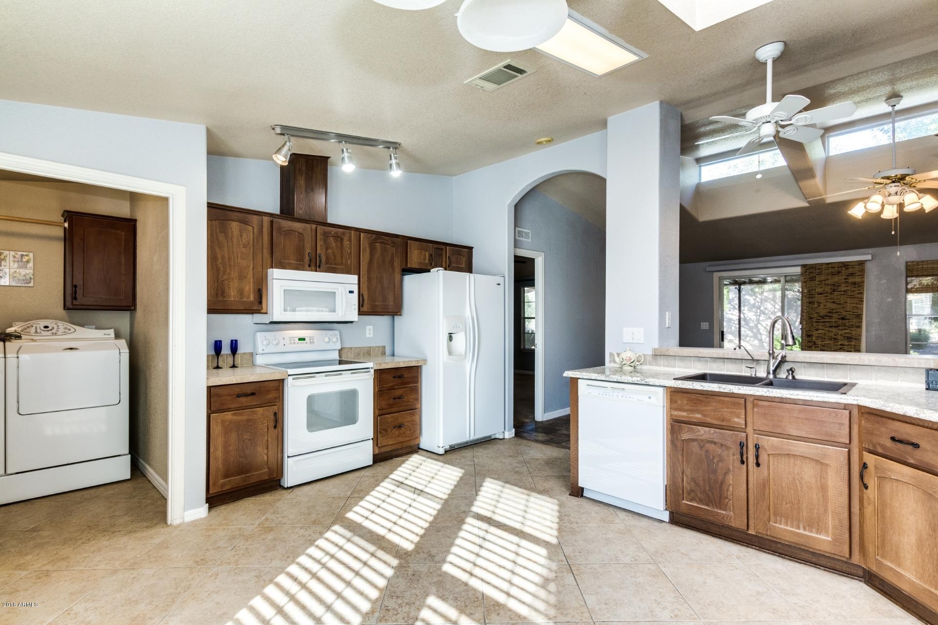 3301 South Goldfield Road, Unit 2041 Apache Junction, AZ 85119 - Photo 9 of 26 a kitchen with a sink stove and refrigerator