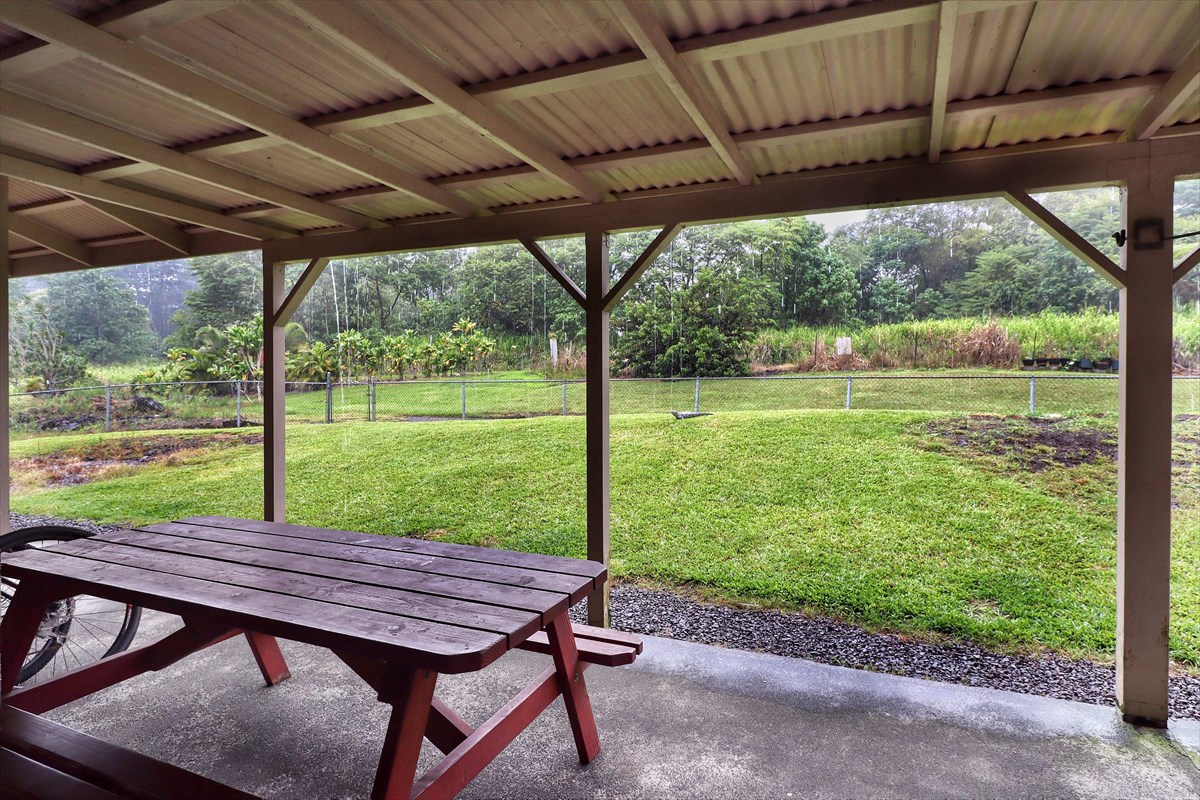 17-212 Volcano Road Keaau, HI 96749 - Photo 16 of 24 a view of a patio with a table chairs and a backyard