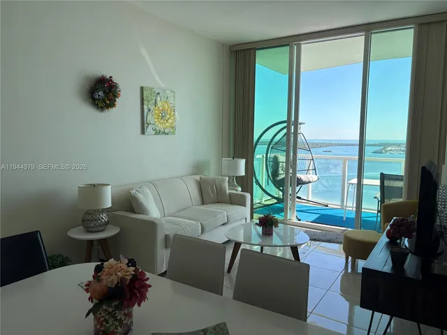 a living room with furniture and a floor to ceiling window