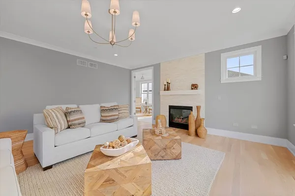 a living room with furniture a fireplace and a chandelier