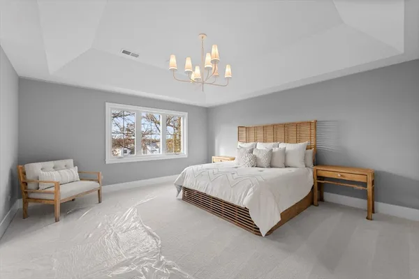 a bedroom with a large bed and a chandelier