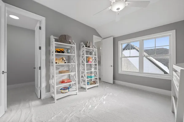 an empty room with bookshelf and windows