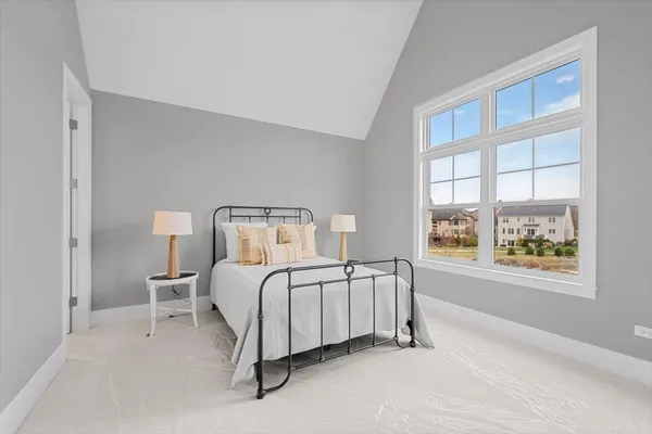 a bedroom with a bed lamp and window
