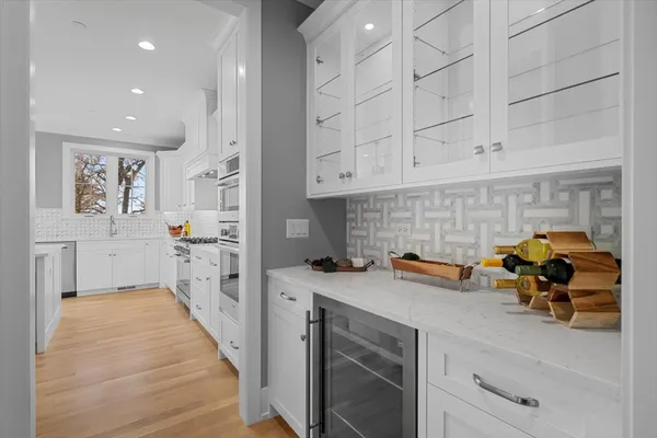 a kitchen with white cabinets and sink