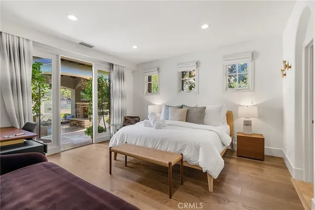 a spacious bedroom with a bed and glass door