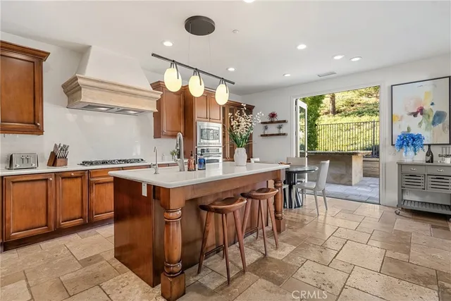 a open kitchen with stainless steel appliances granite countertop a table chairs sink and cabinets