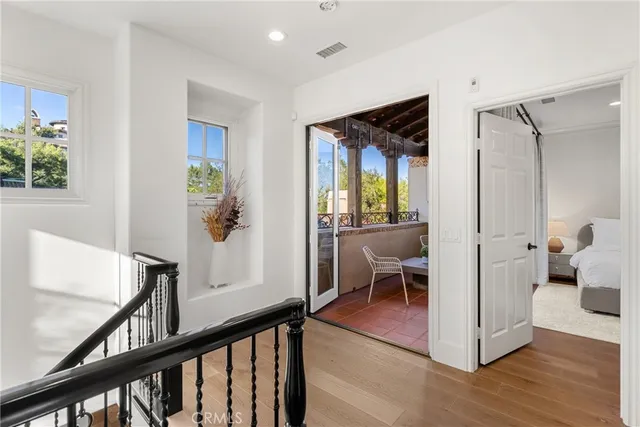 a view of a hallway to a livingroom with furniture and windows