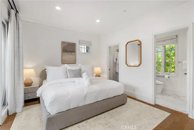 a bedroom with a bed mirror and a window