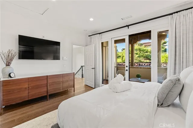 a bedroom with a large bed and a flat screen tv