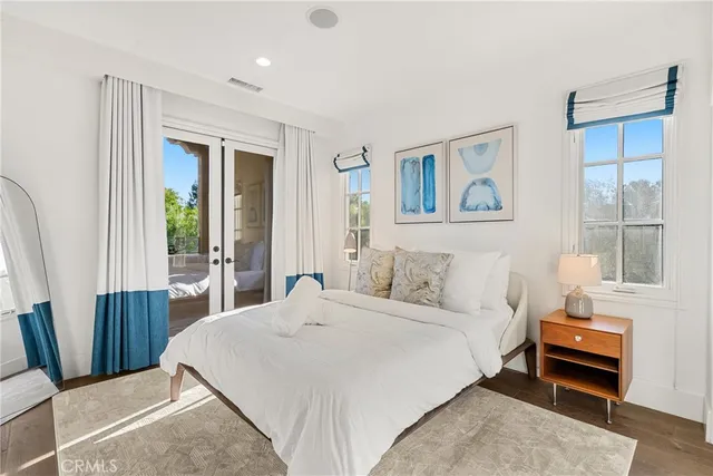 a bedroom with a bed a dresser and next to a window