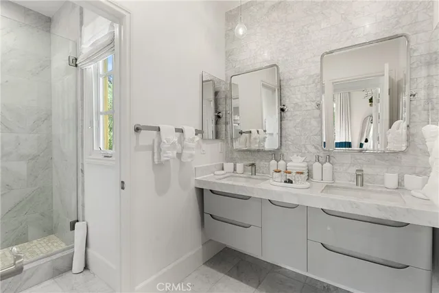 a bathroom with a double vanity sink mirror and shower