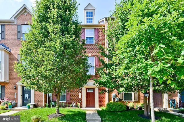 a kitchen with stainless steel appliances granite countertop a refrigerator a stove top oven a sink dishwasher and white cabinets with wooden floor