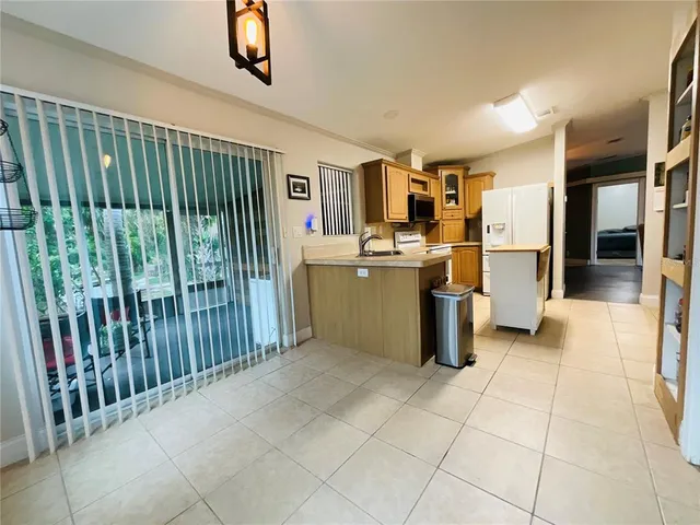 a open kitchen with stainless steel appliances granite countertop a refrigerator and a stove top oven