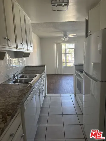 a kitchen with a sink a stove and cabinets