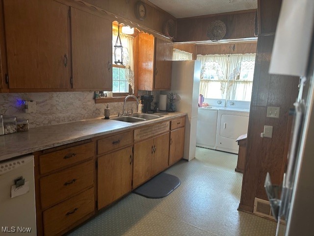 976 East Calla Road Youngstown, OH 44514 - Photo 4 of 10 Kitchen featuring white dishwasher, light countertops, light floors, tasteful backsplash, and brown cabinets