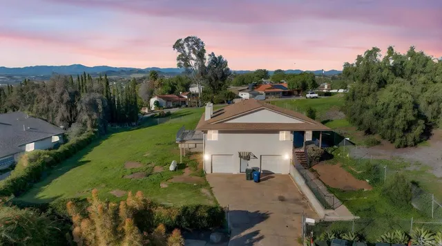 a front view of a house with a yard and trees