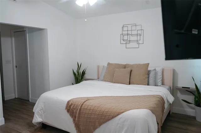 a bed sitting in a bedroom next to a window with wooden floor