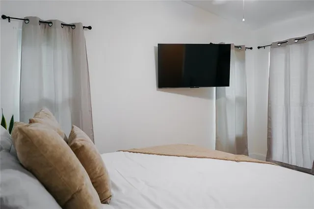 a bedroom with a bed and a flat screen tv