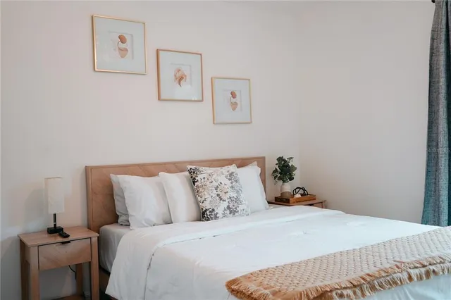 a bedroom with a bed and painting on the wall