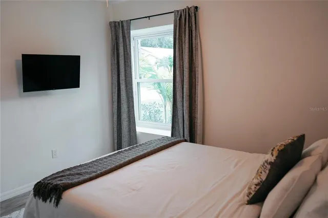 a bedroom with a bed and a flat tv screen