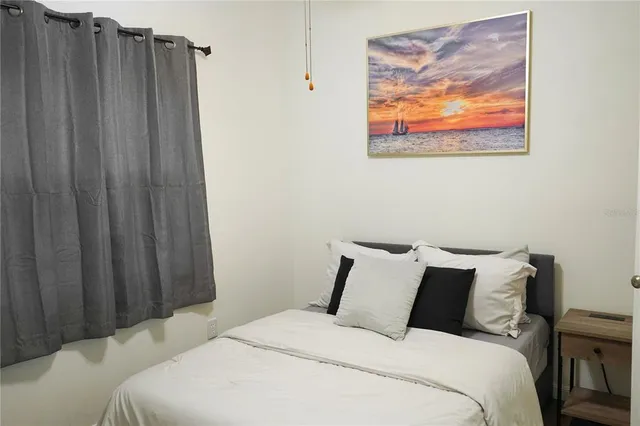 a bedroom with bed and wooden floor
