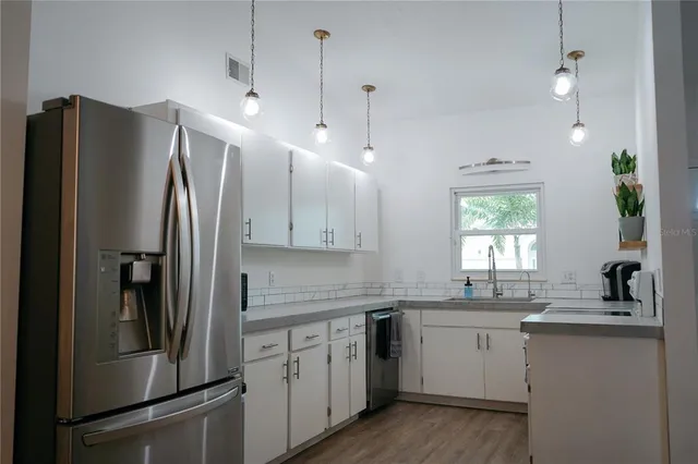 a kitchen with a refrigerator sink and white cabinets