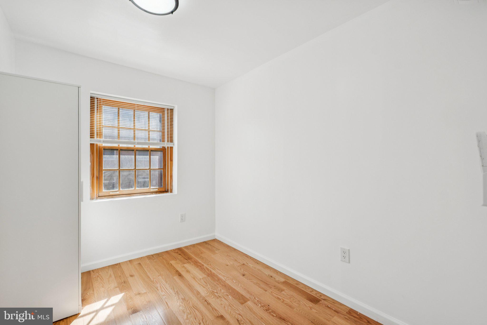1223 Spruce Street, Unit 3F Philadelphia, PA 19107 - Photo 16 of 37 a view of an empty room with wooden floor and a window