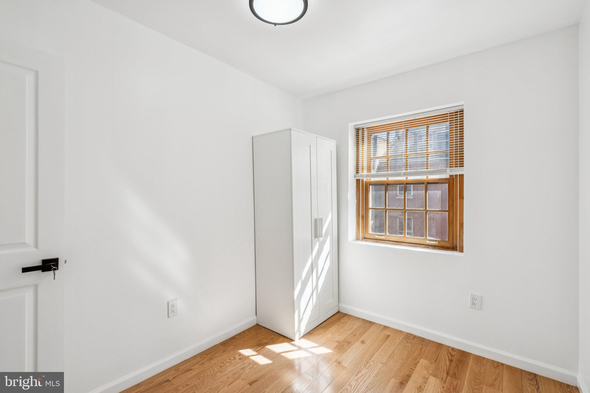 1223 Spruce Street, Unit 3F Philadelphia, PA 19107 - Photo 18 of 37 a view of an empty room with wooden floor and a window