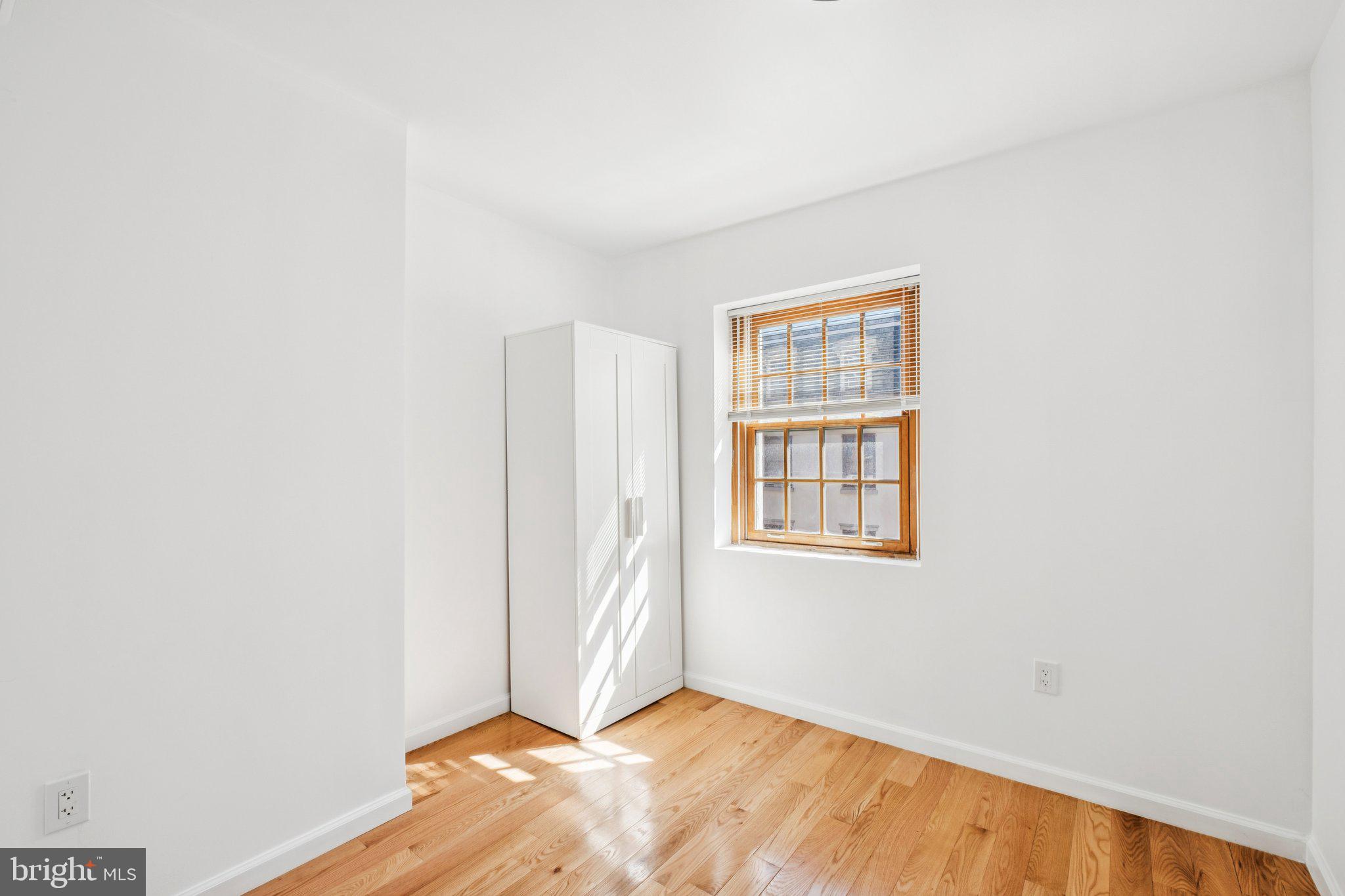 1223 Spruce Street, Unit 3F Philadelphia, PA 19107 - Photo 21 of 37 a view of an empty room with wooden floor and a window