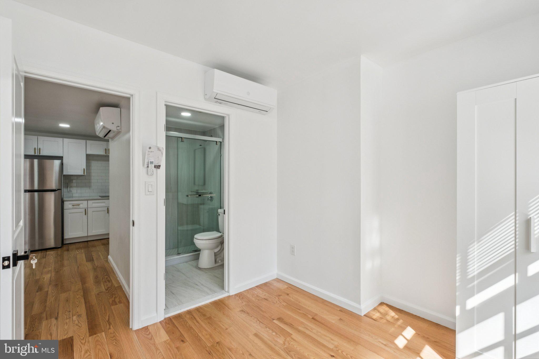 1223 Spruce Street, Unit 3F Philadelphia, PA 19107 - Photo 22 of 37 a view of a hallway with wooden floor and a living room