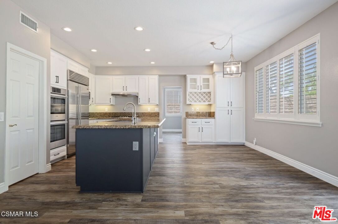 335 Kitetail Street Simi Valley, CA 93065 - Photo 10 of 37 a kitchen with stainless steel appliances granite countertop a refrigerator a sink dishwasher and a stove with wooden floor