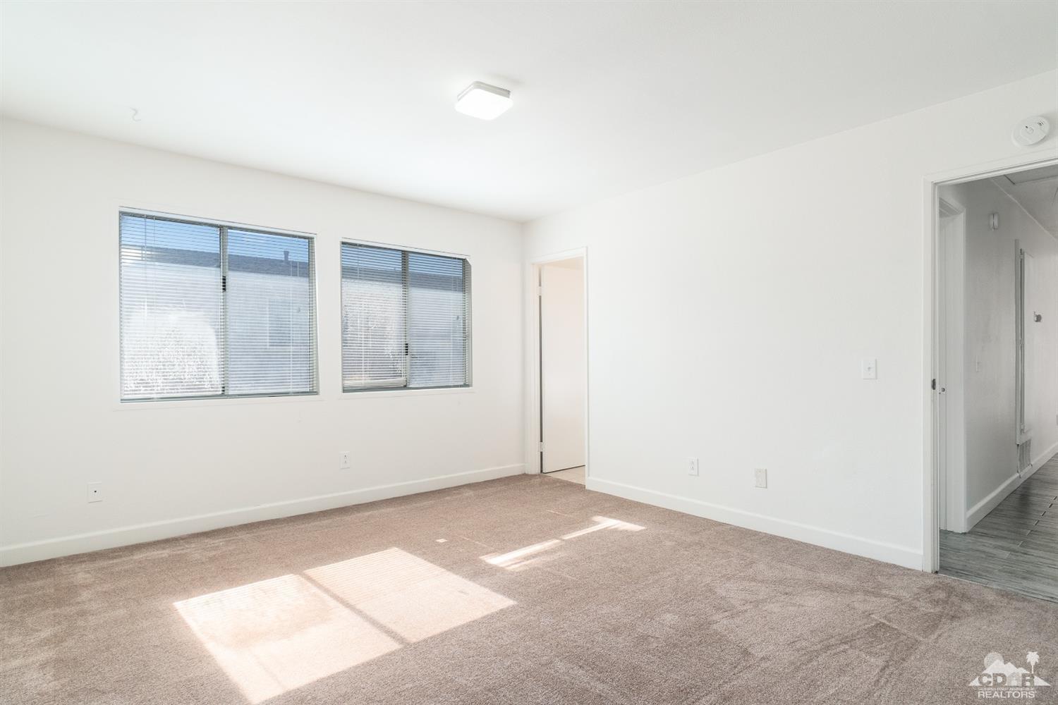 66186 Santa Rosa Road Desert Hot Springs, CA 92240 - Photo 13 of 23 an empty room with wooden floor and windows