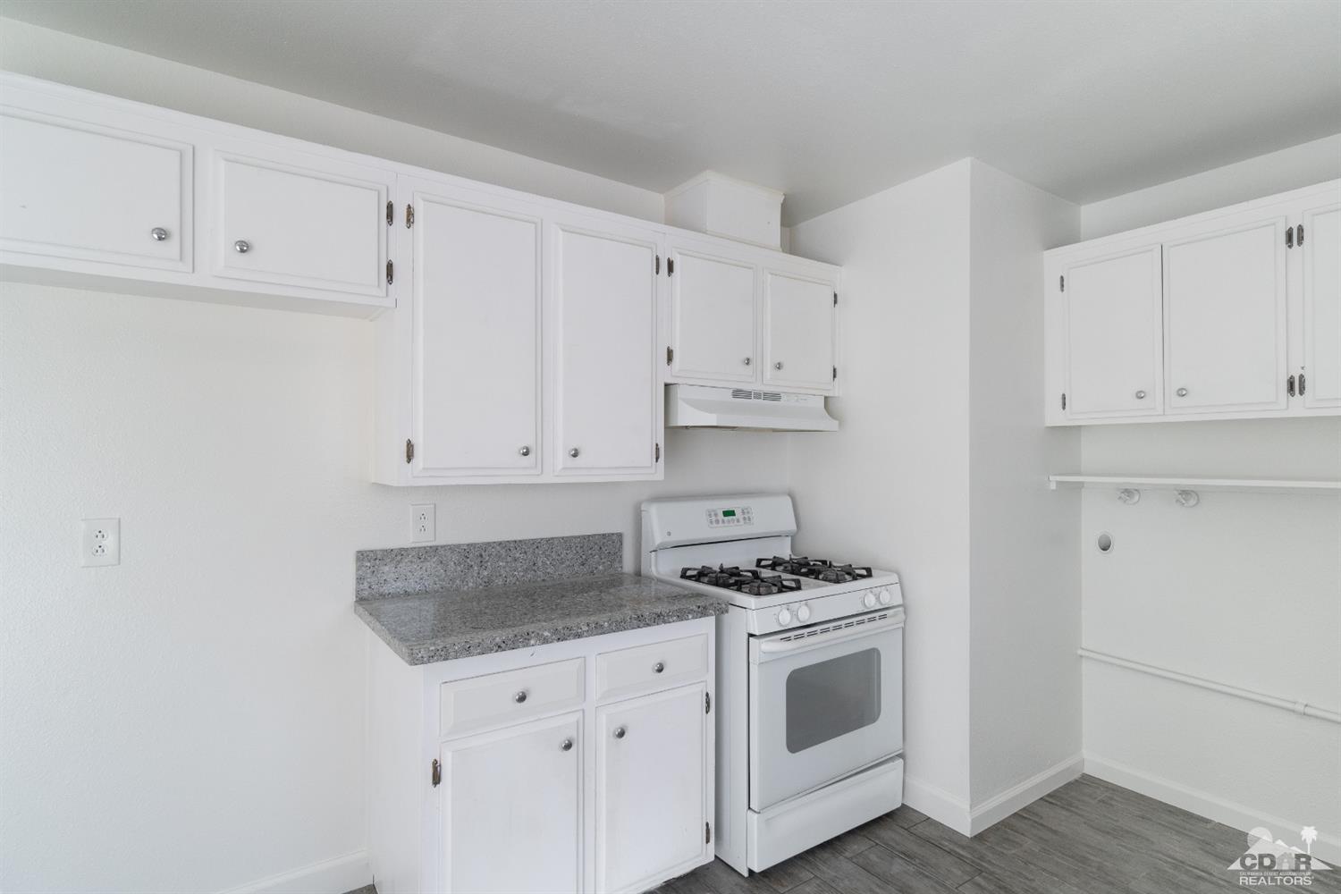 66186 Santa Rosa Road Desert Hot Springs, CA 92240 - Photo 3 of 23 a kitchen with white cabinets and white appliances
