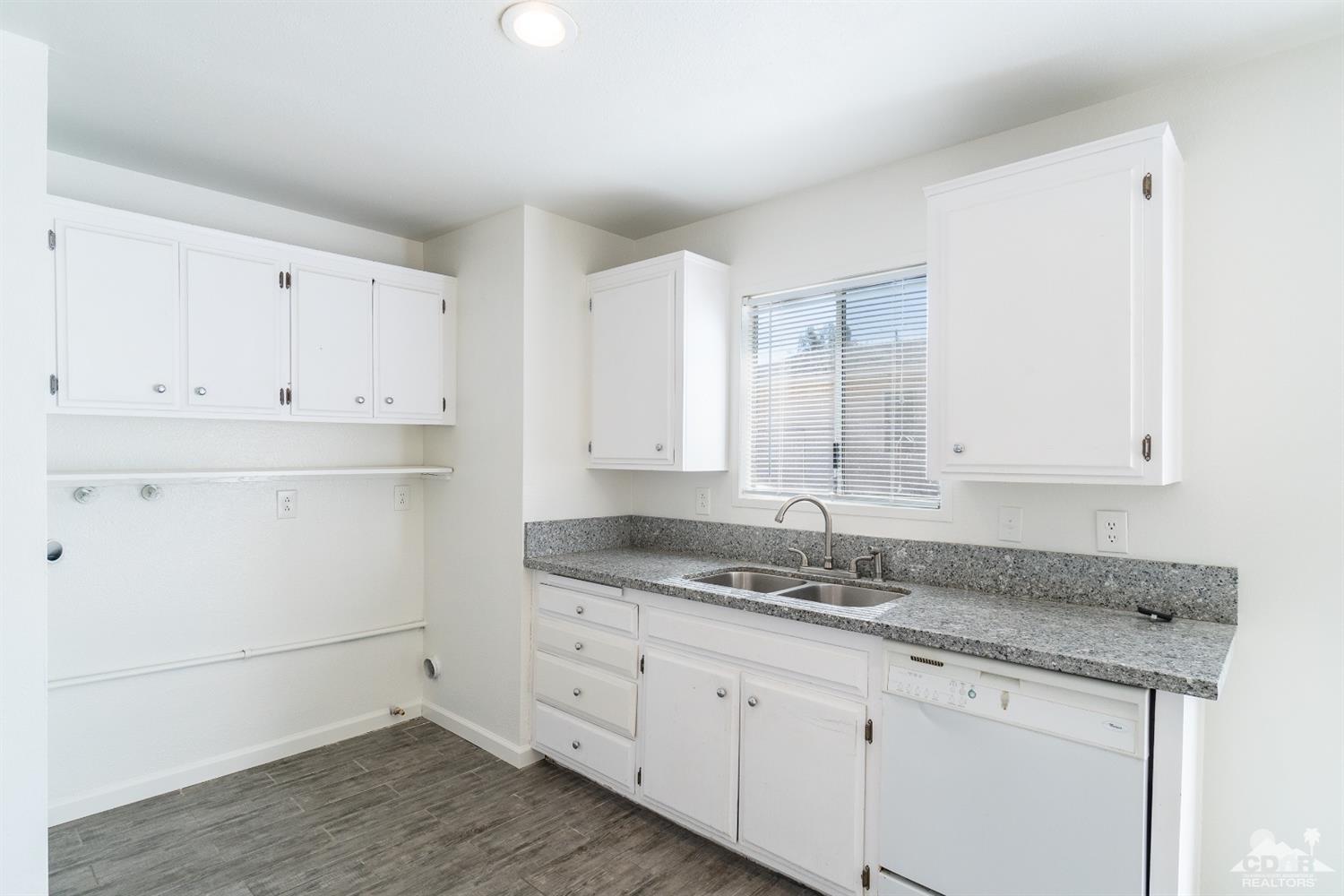 66186 Santa Rosa Road Desert Hot Springs, CA 92240 - Photo 7 of 23 a kitchen with granite countertop white cabinets and white appliances