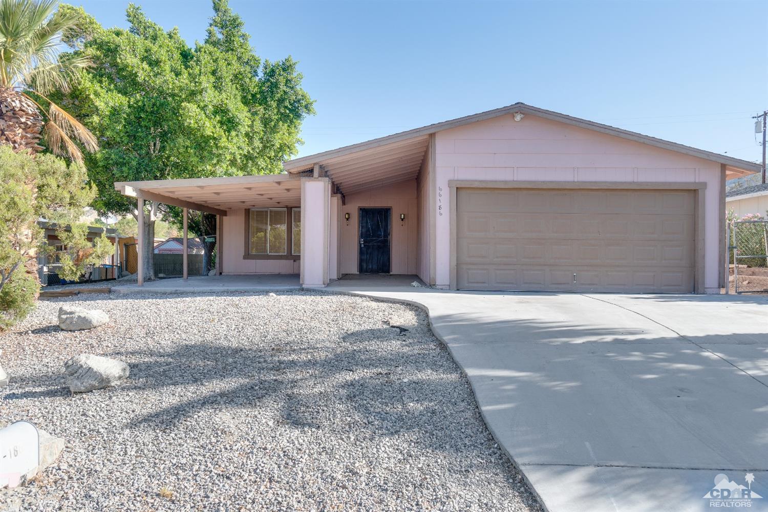 66186 Santa Rosa Road Desert Hot Springs, CA 92240 - Photo 8 of 23 a front view of a house with a yard and garage