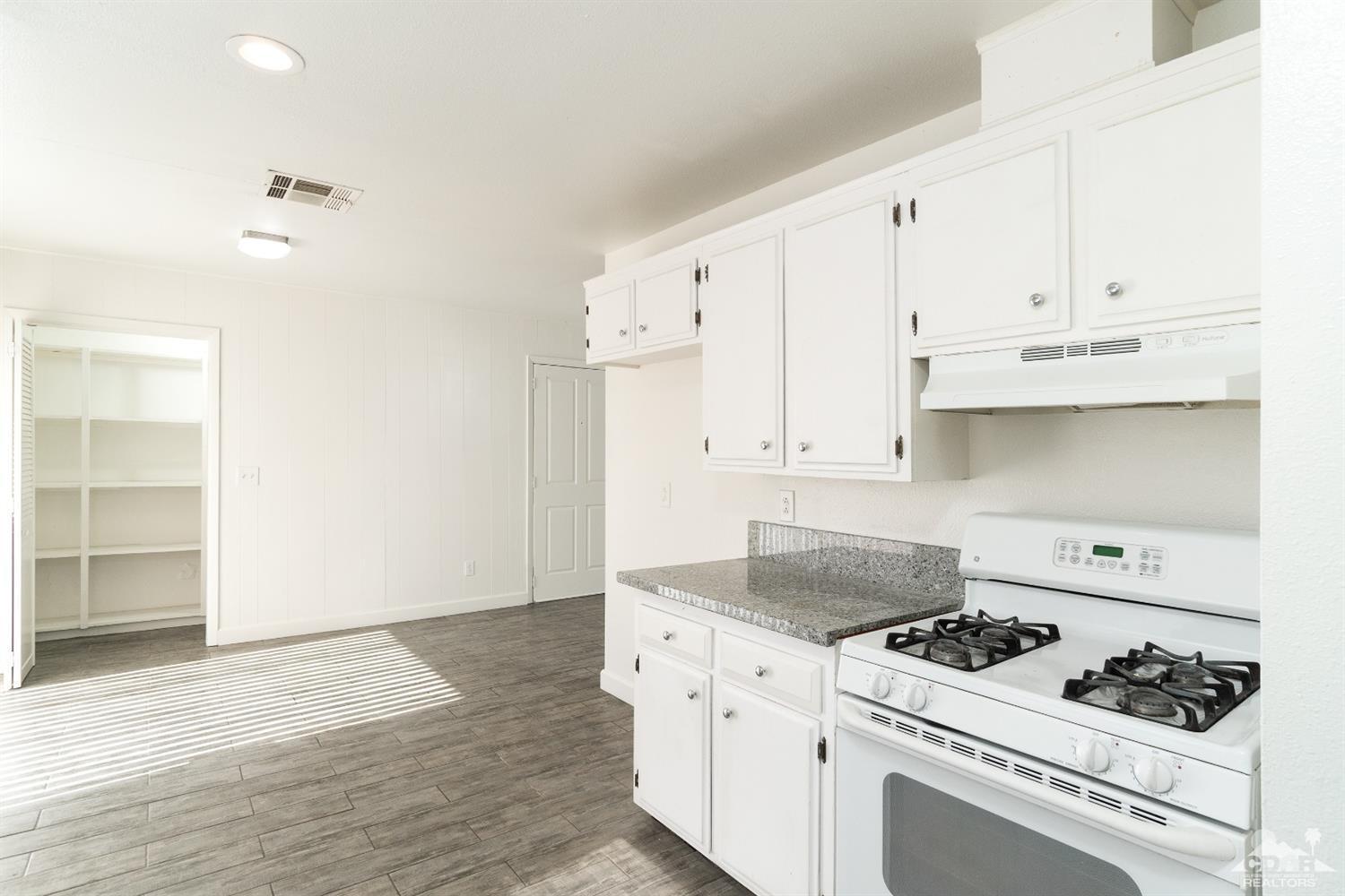 66186 Santa Rosa Road Desert Hot Springs, CA 92240 - Photo 9 of 23 a kitchen with white cabinets and appliances
