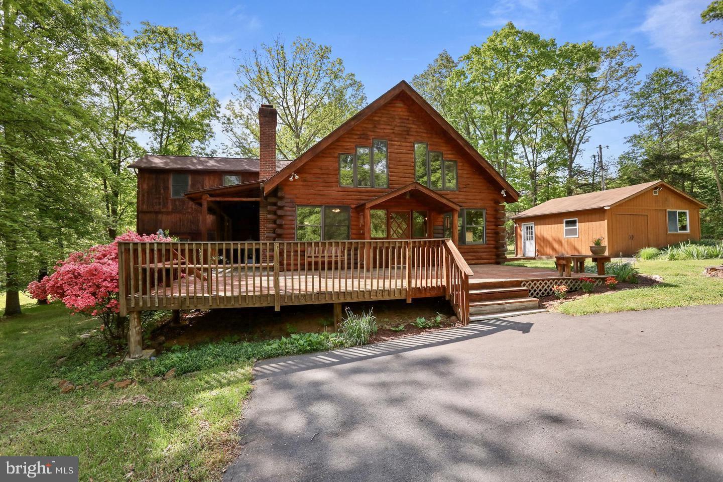 a view of a house with a yard and a wooden deck