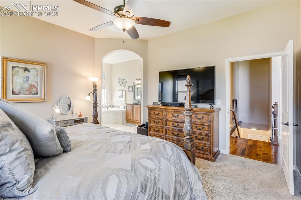 13214 Cake Bread Heights Colorado Springs, CO 80921 - Photo 15 of 28 a bedroom with a bed and a chandelier