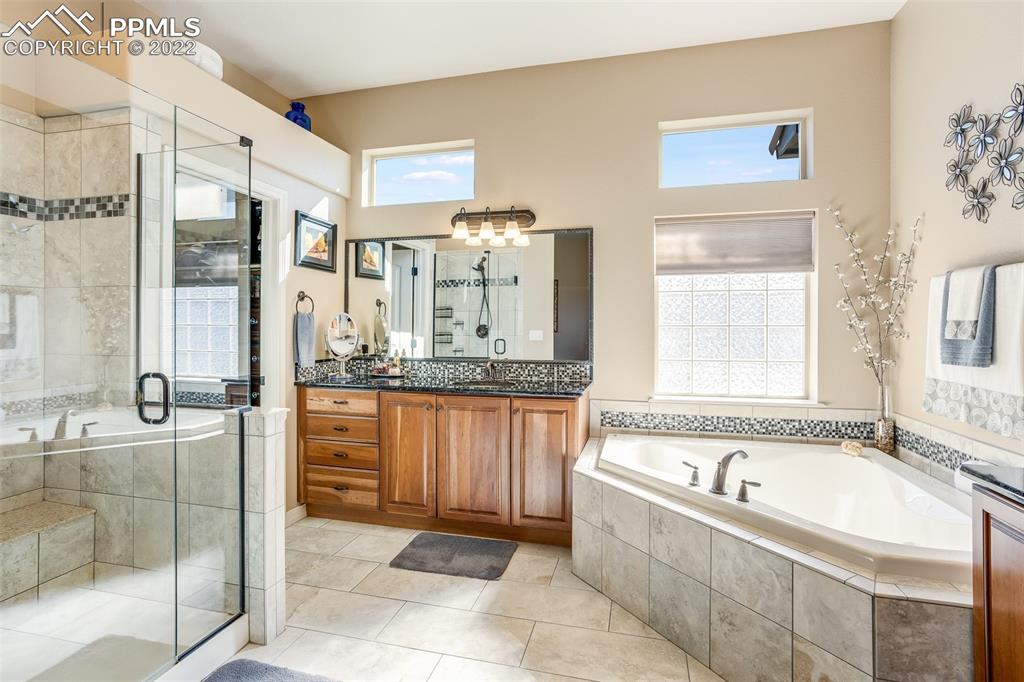 13214 Cake Bread Heights Colorado Springs, CO 80921 - Photo 16 of 28 a bathroom with a granite countertop tub sink and mirror
